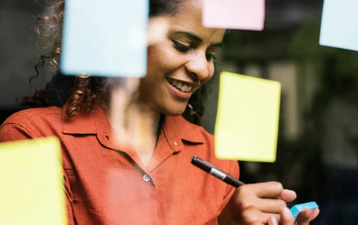 Woman builds a checklist to help empower her teams. She's thankful for Kudos, the employee recognition program that excelerates workplace culture. 