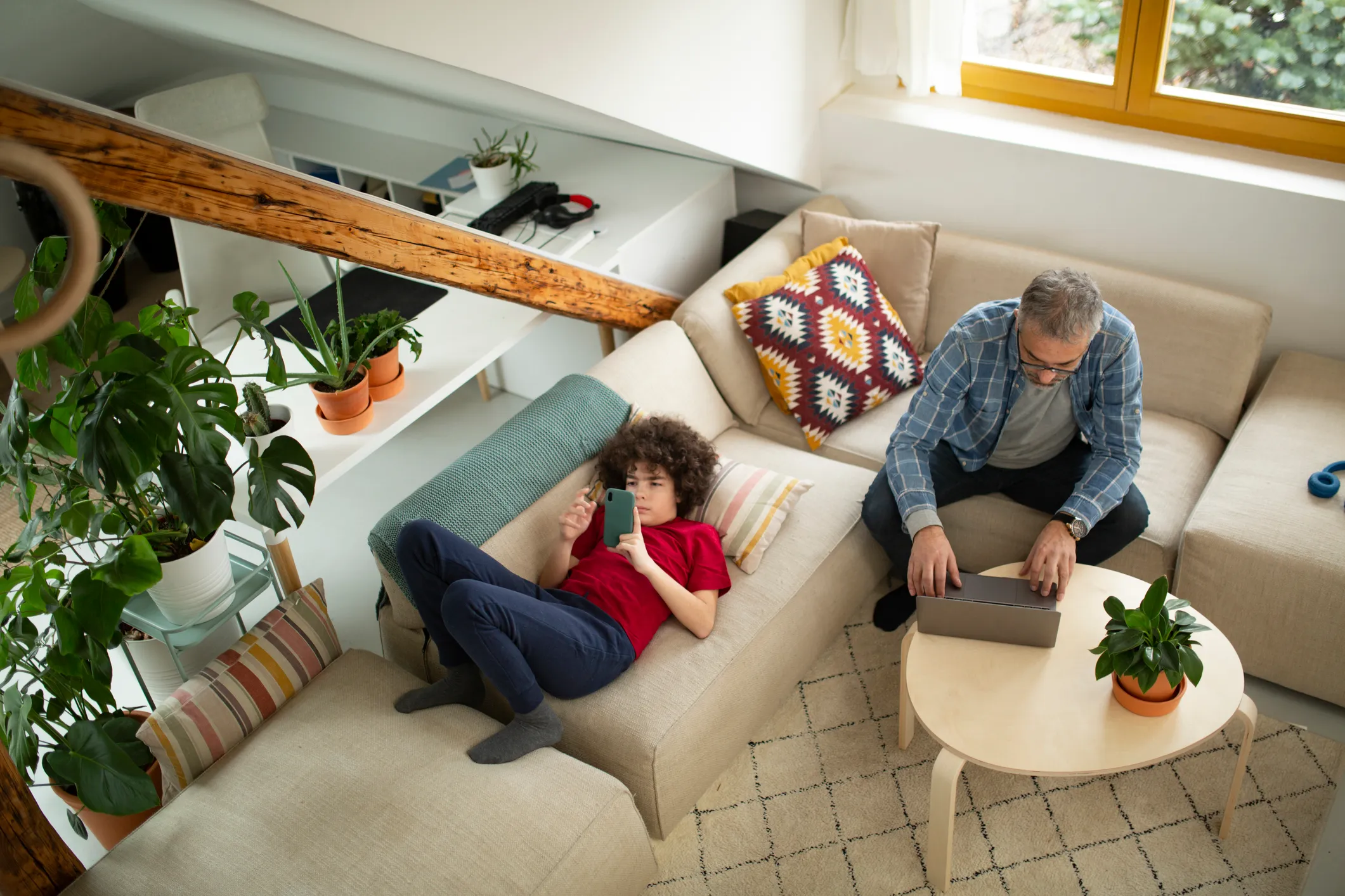 Couple working at home from the couch. By using Kudos and these tips, both can better their employee experience at home. 