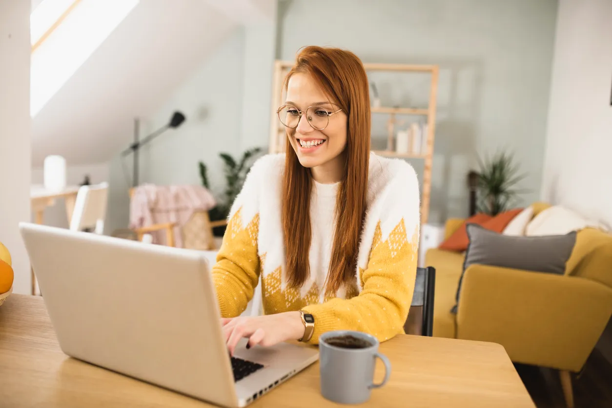 Woman sending holiday recognition message to team from laptop.