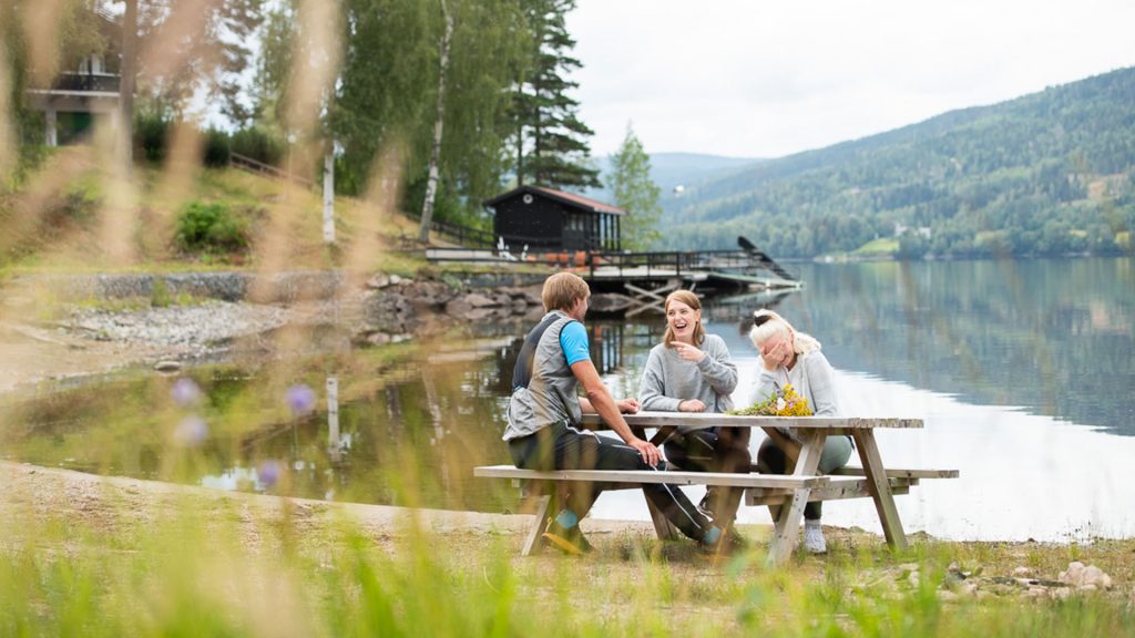 Spesialisthelsetjeneste i Hurdal, Viken, Recoveryklinikkene. Miljøbilde med samtale mellom tre personer med utsikt over Hurdalsjøen