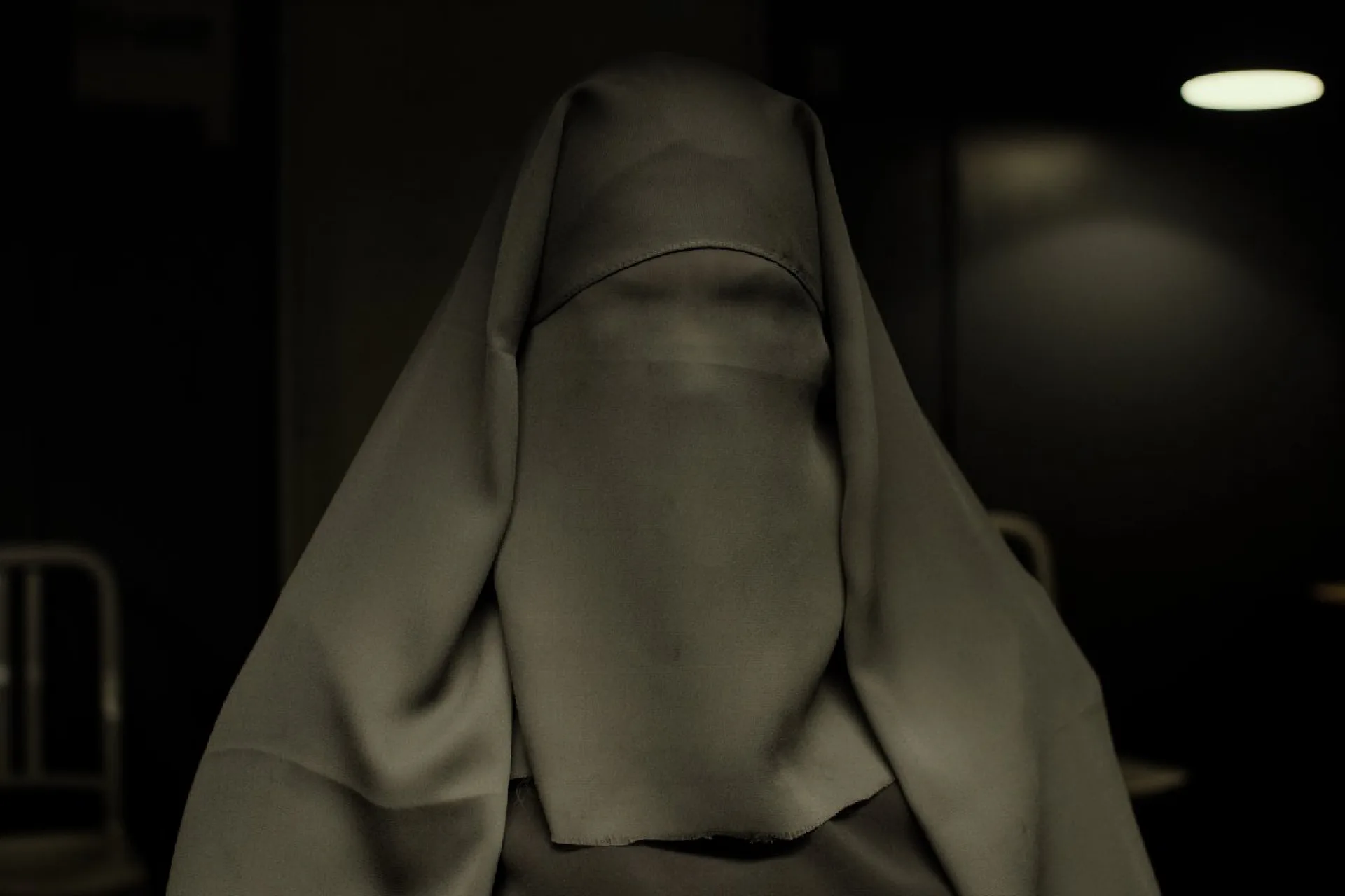 The mother, face hidden by her burqa, in the Copenhagen police station, still from Listen (2014)