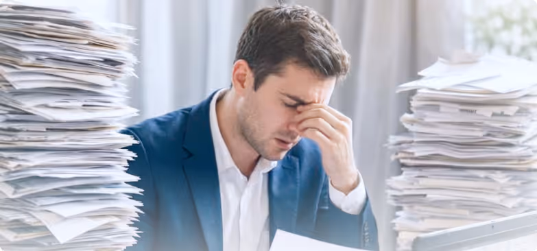 Group of five young professionals smiling and celebrating around a laptop in a modern office.