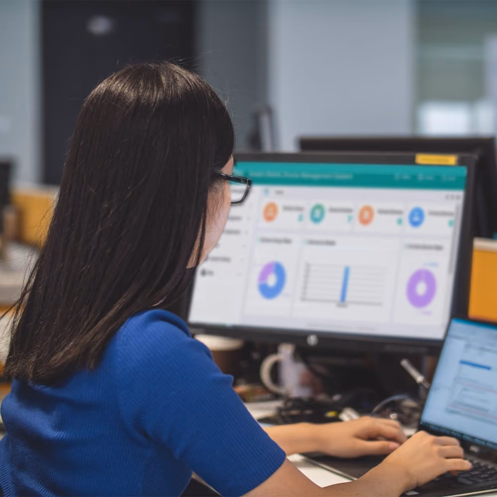 Woman sitting at desk in front of Aratek device management system for controlling Aratek biometric mobile ID terminals