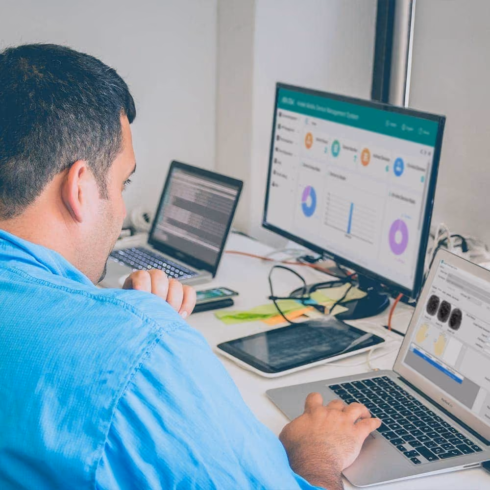 Man sitting at desk in front of Aratek device management system for controlling Aratek biometric mobile ID devices