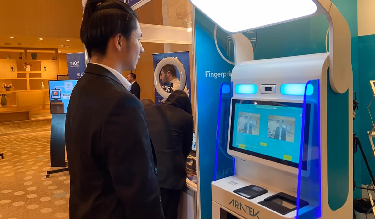 A man using facial recognition on the Aratek biometrics airport self check-in kiosk