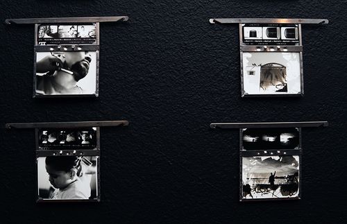 Close up of 4 hangers featuring works of family members and alternative processing methods.