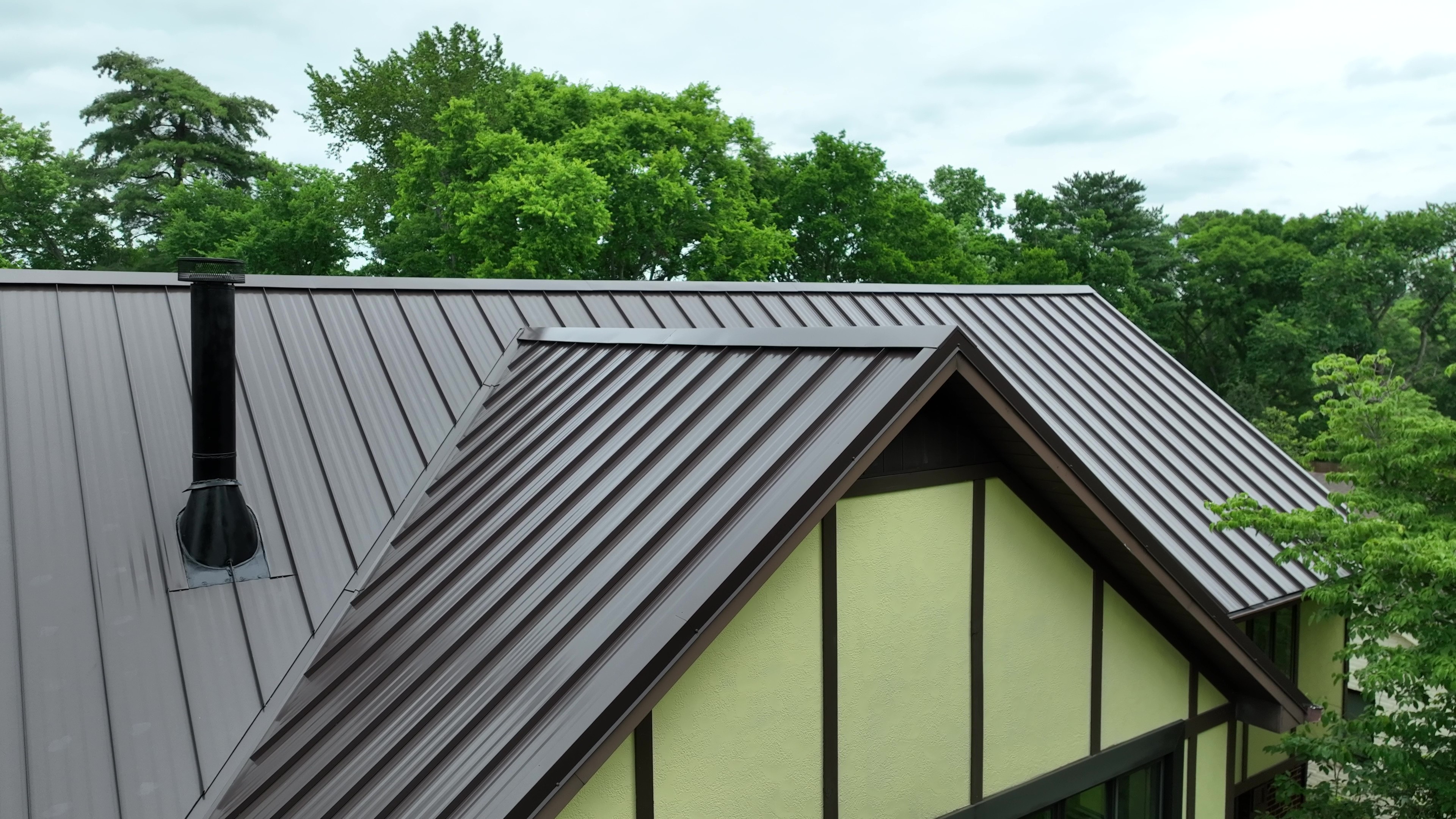 Mansard Brown Standing Seam Tudor Home