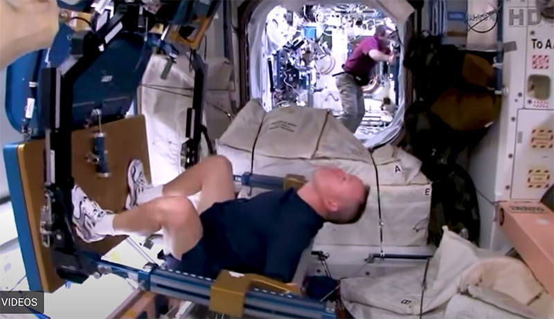 An astronaut doing squats with the ARED (Advanced Resistive Exercise Device) on the International Space Station