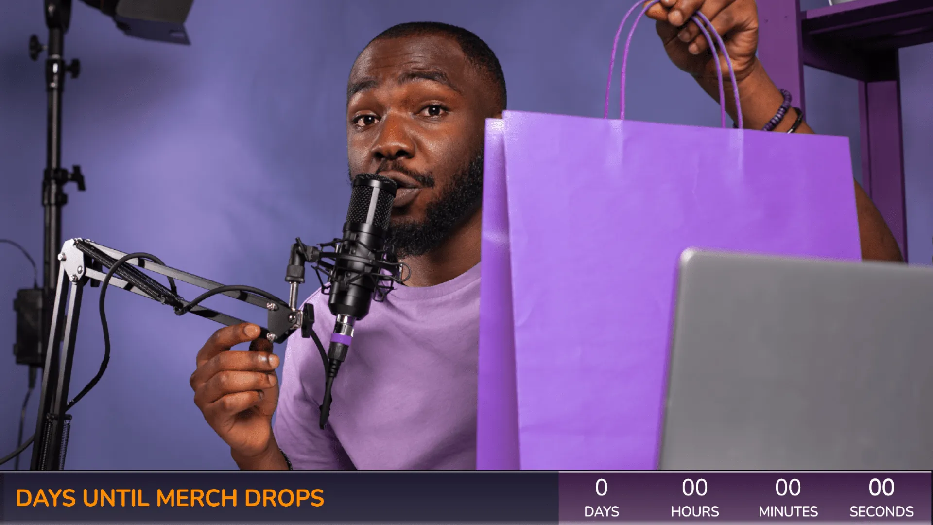 A live streamer showing off merch, with a merch countdown overlay in the lower third of the screen.