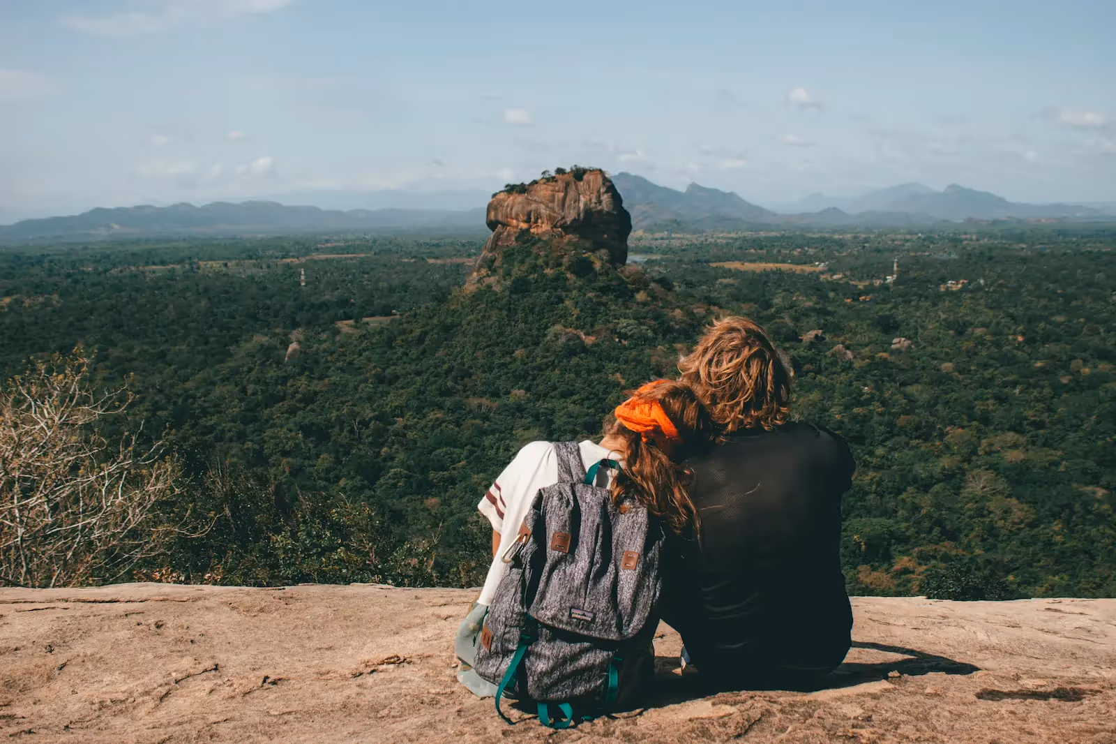 Two people sitting by a cliff