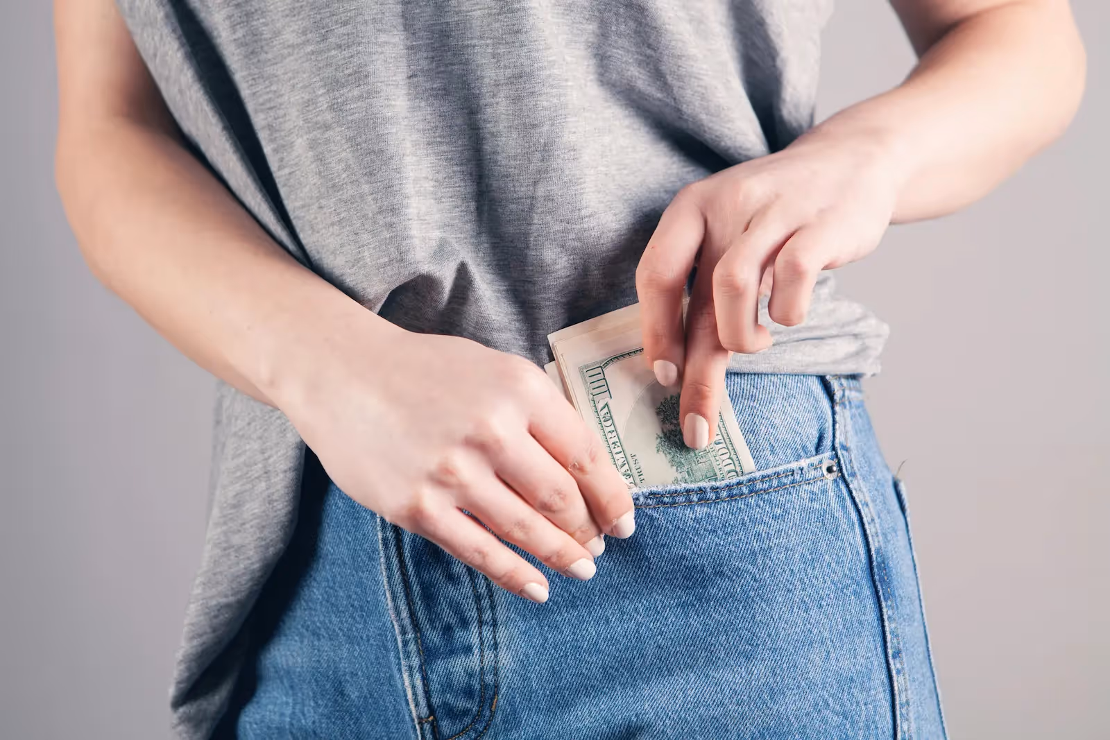 Person putting money in their jean pocket