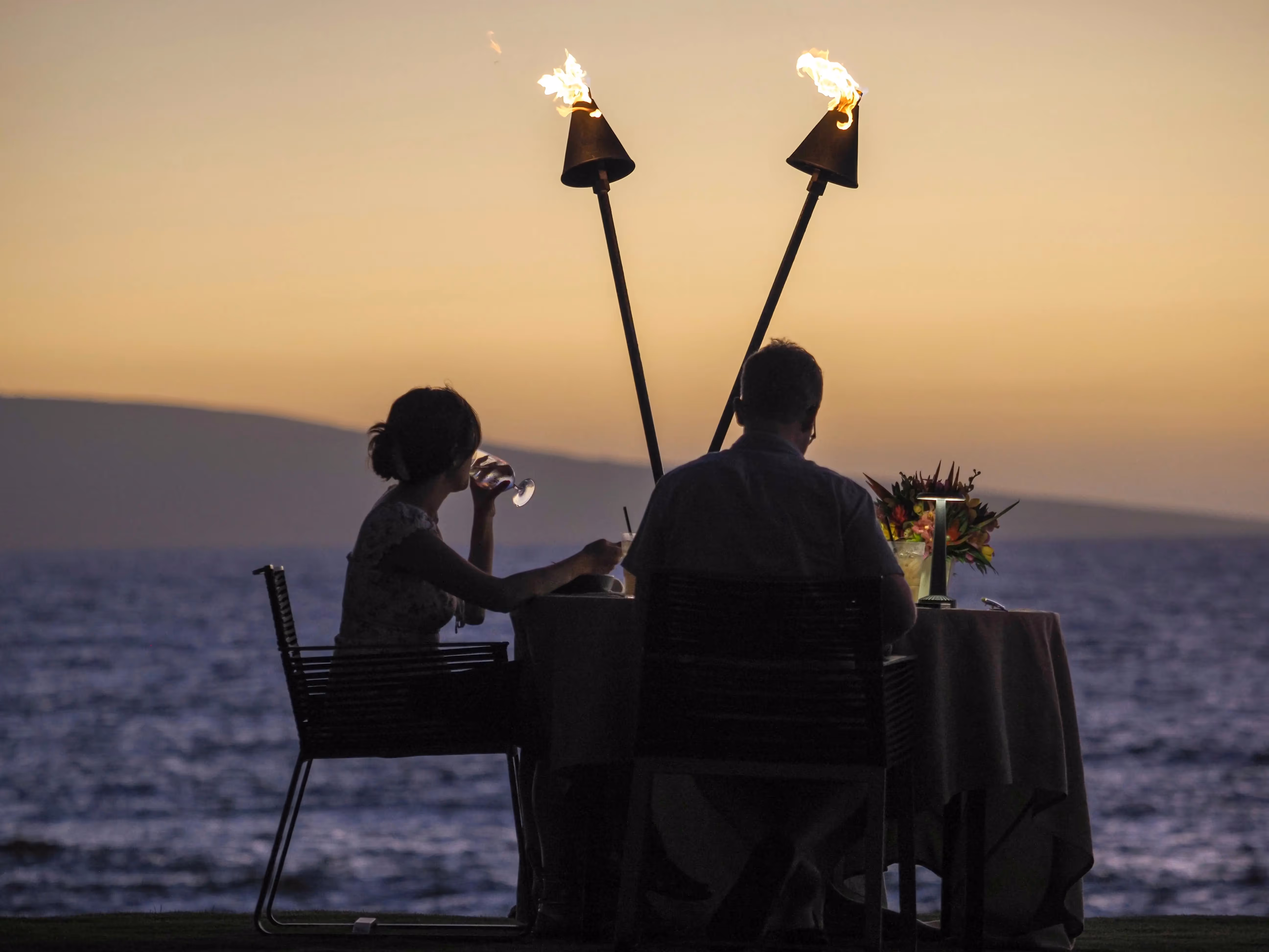 Two people eating by the sea