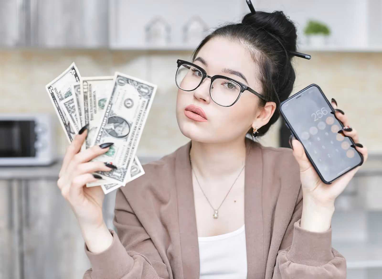 Person holding money and a phone