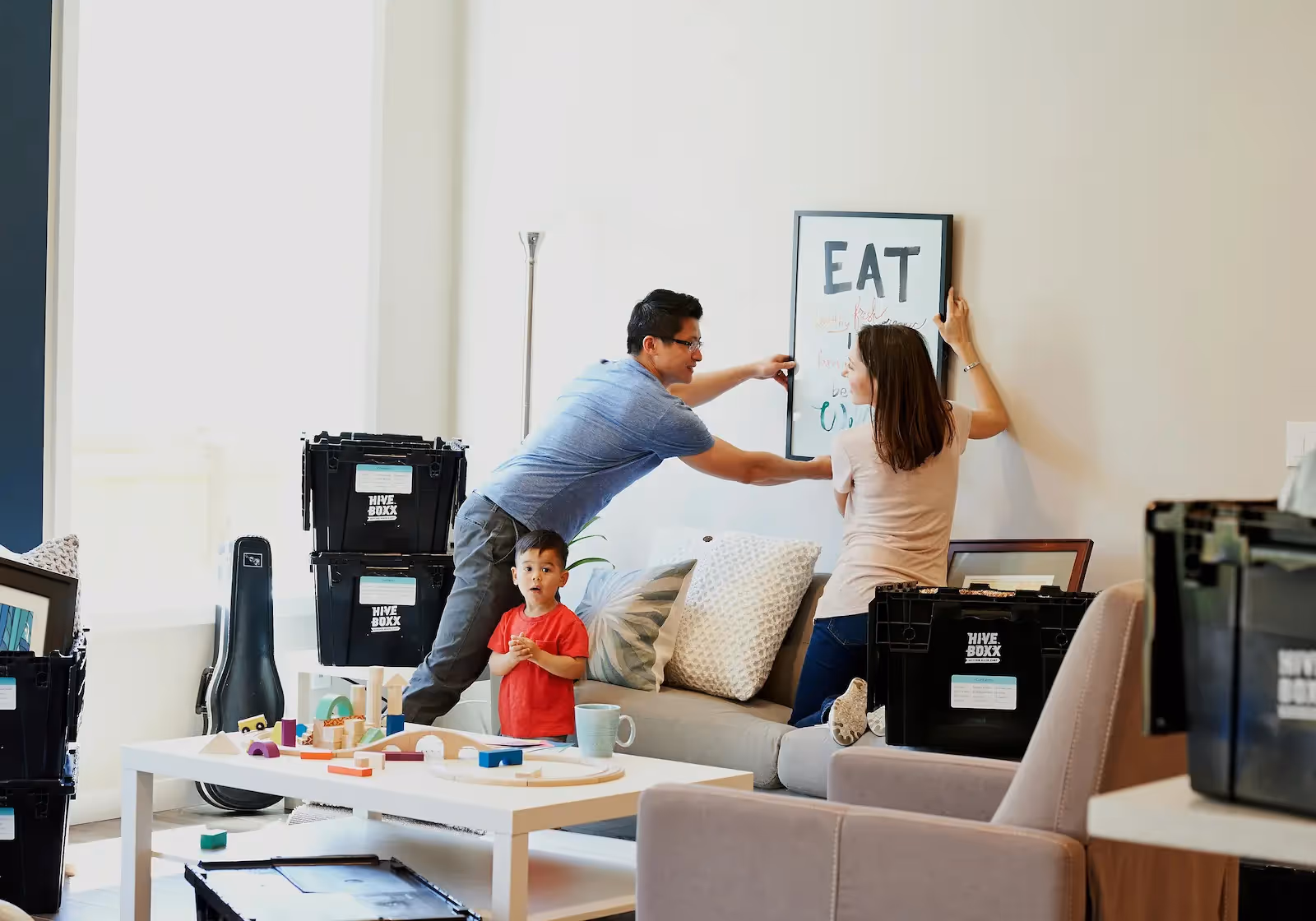 Two people hanging a frame