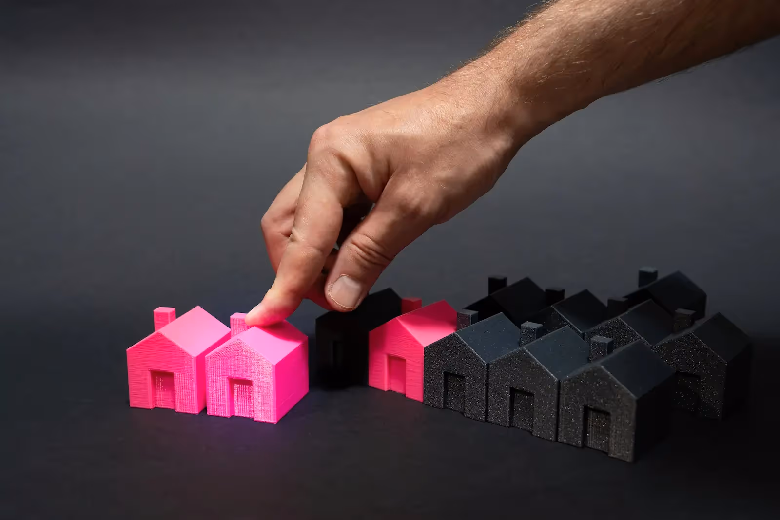 Person pointing at a miniature house