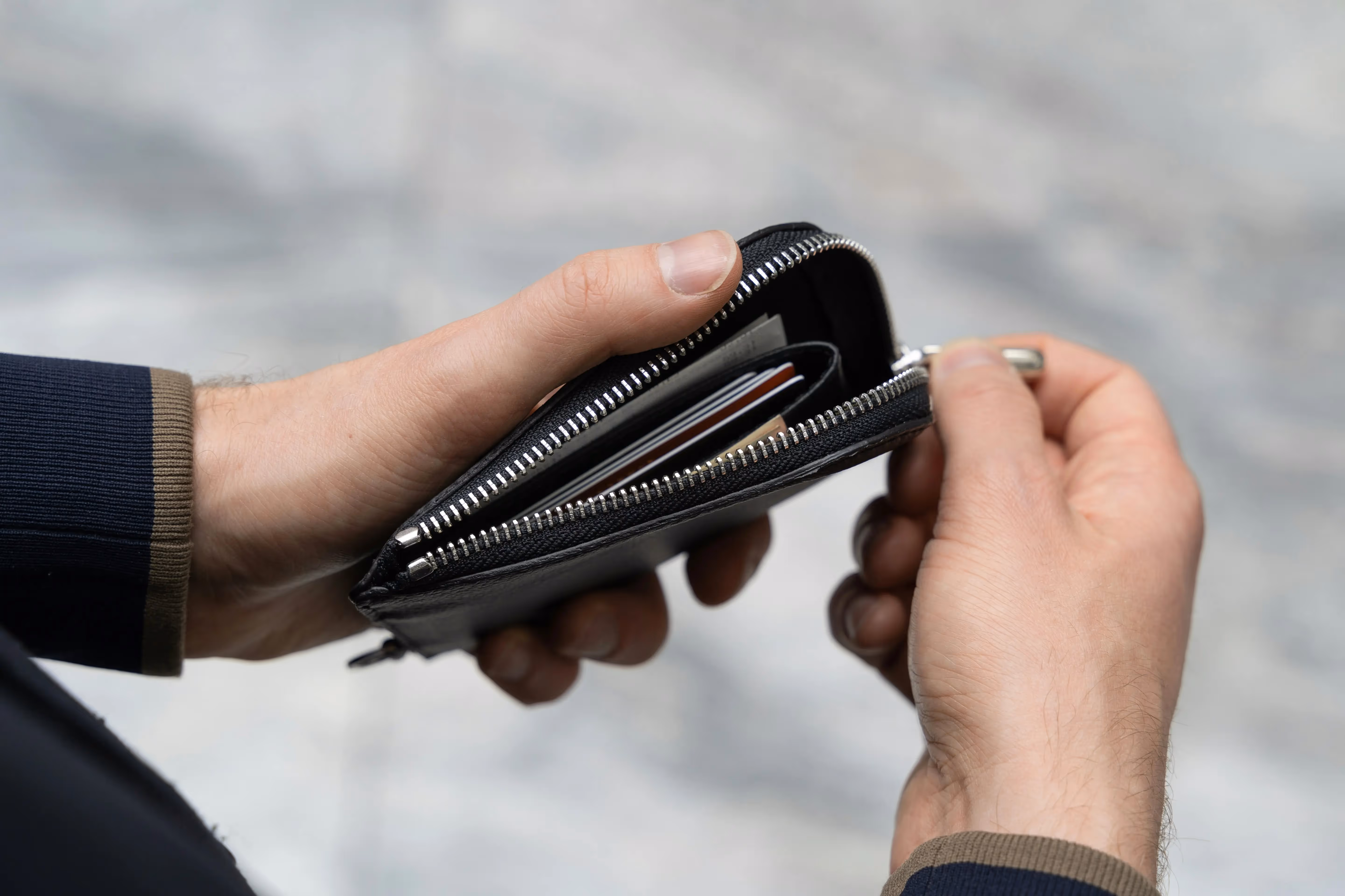 Person holding a black wallet