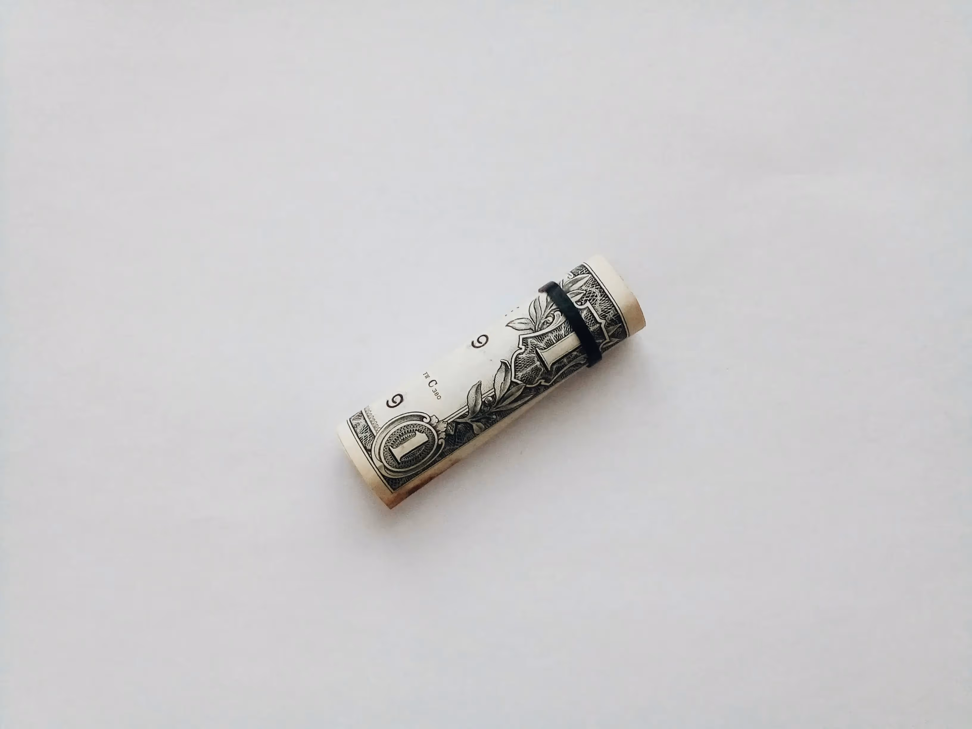 A rolled one dollar bill