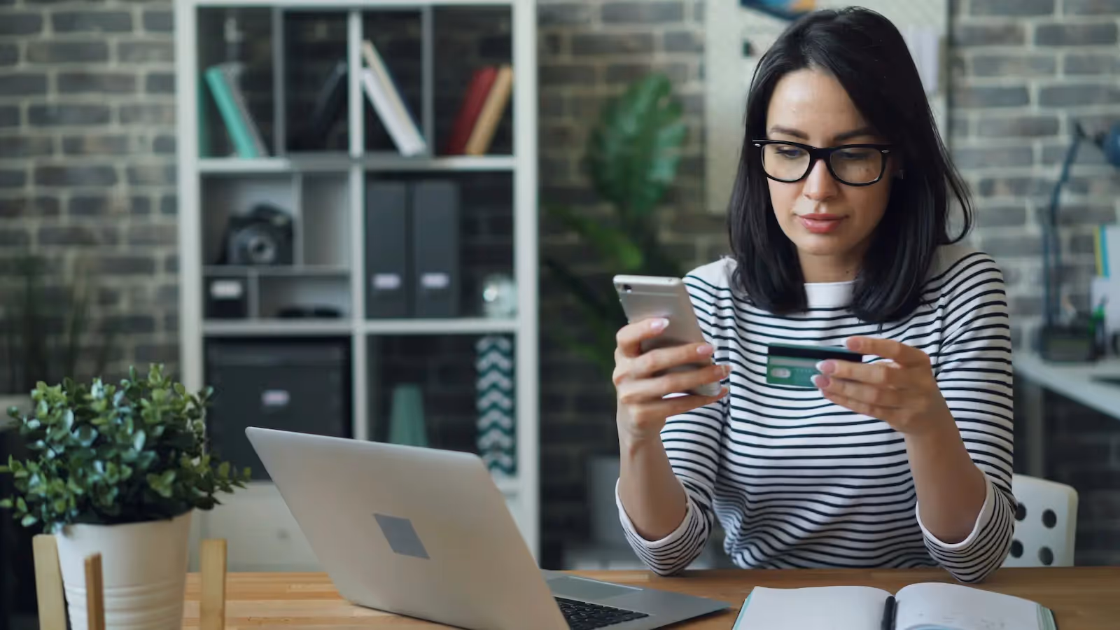 Person holding a phone and a credit card
