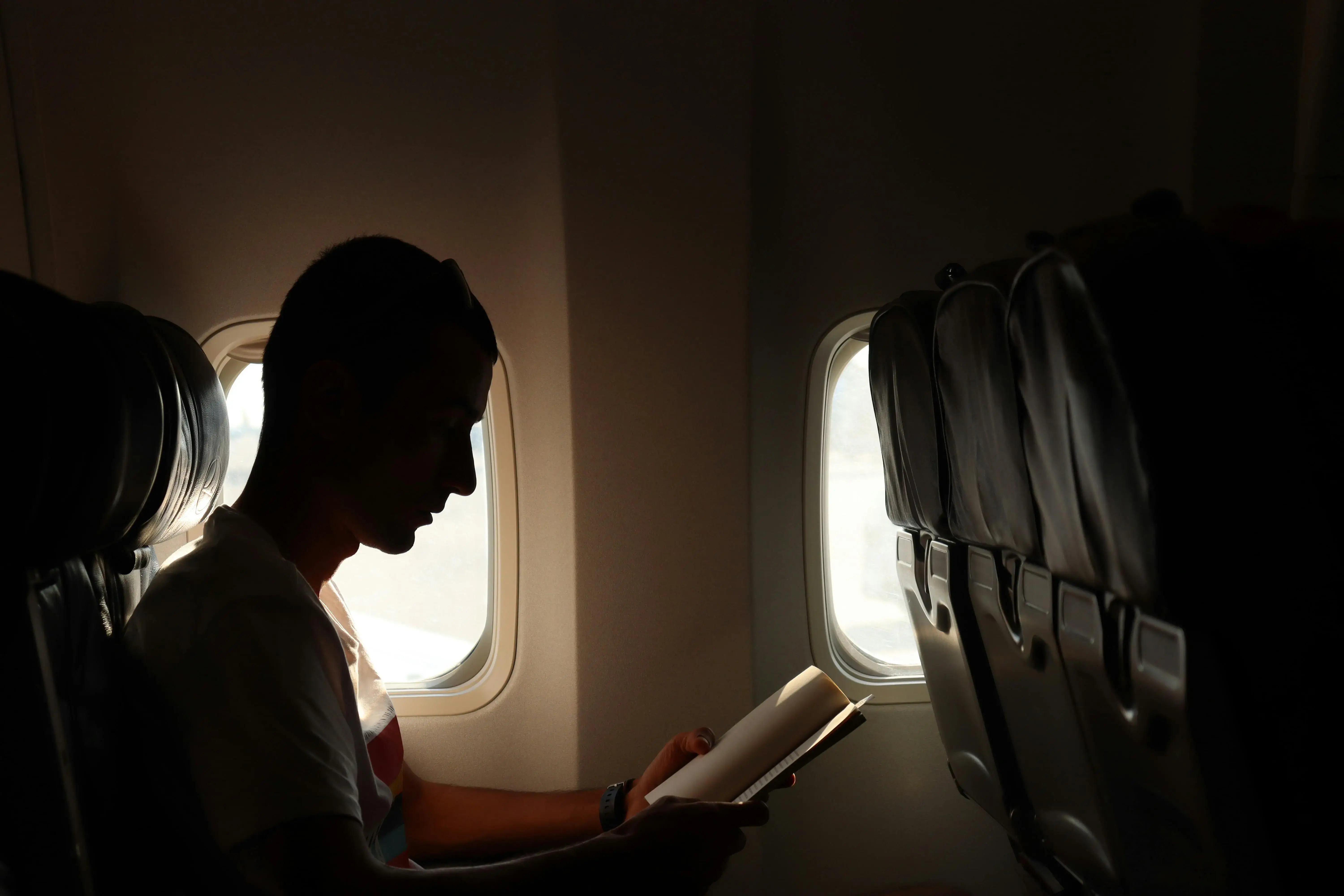 Man reading inside a plane