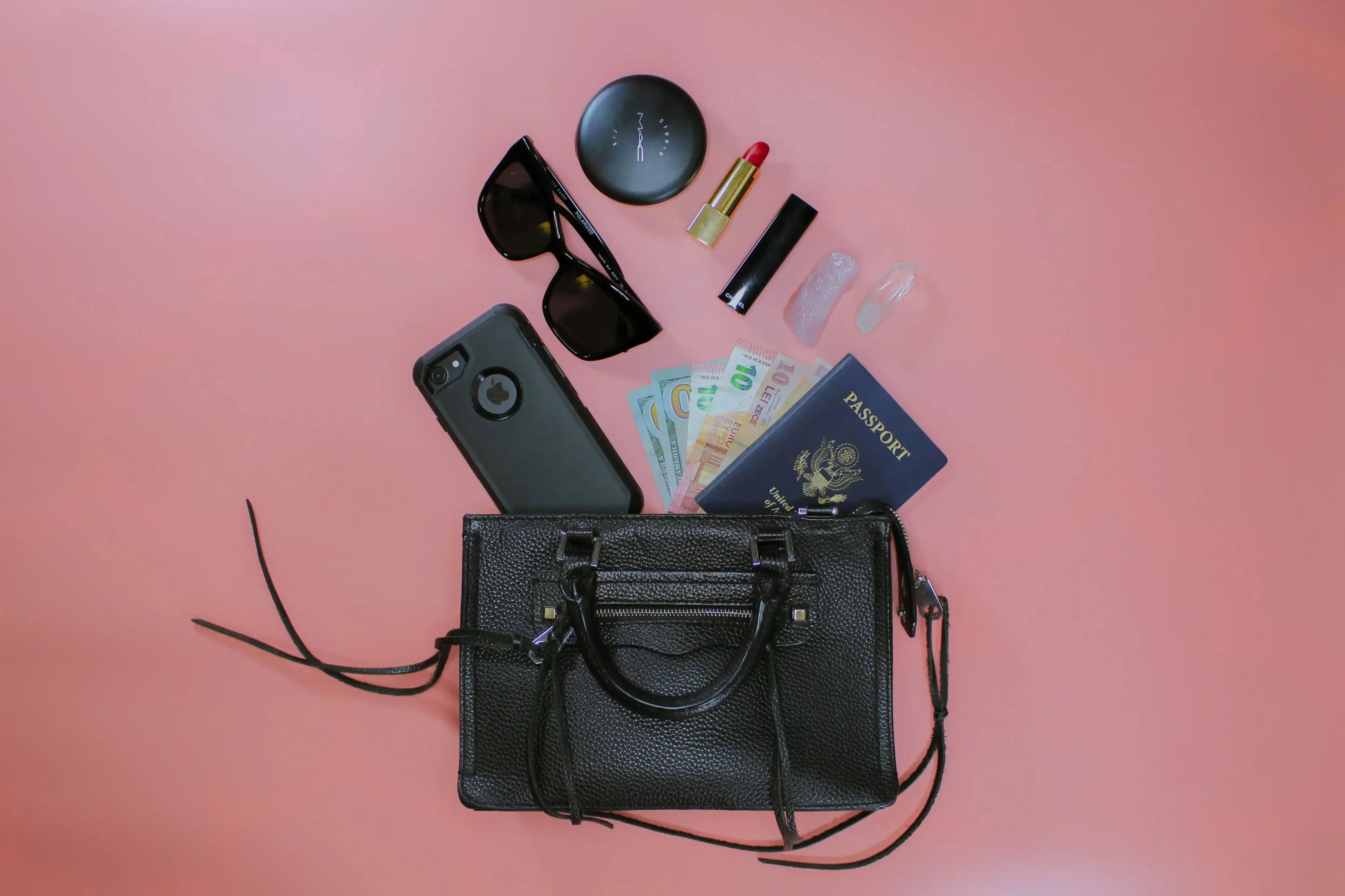 Travel essentials on a pink surface