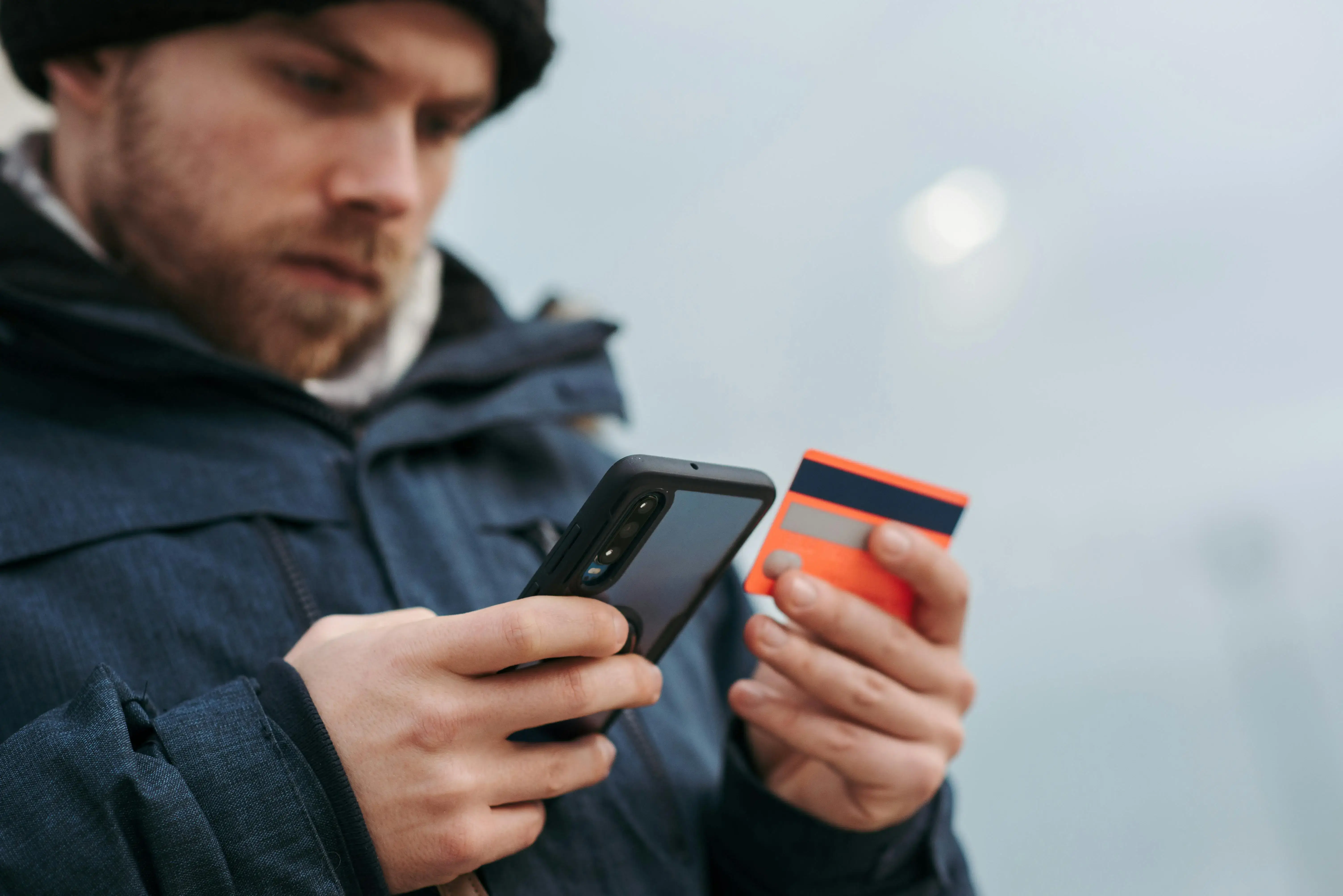 Man holding a credit card and a phone