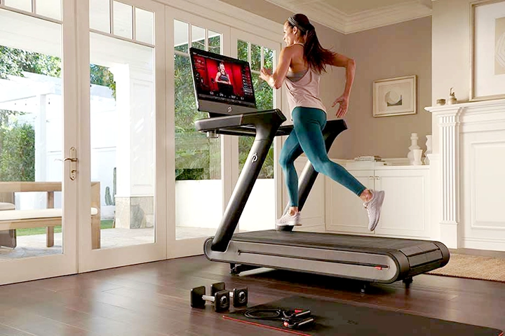 A woman runs on a Peloton treadmill