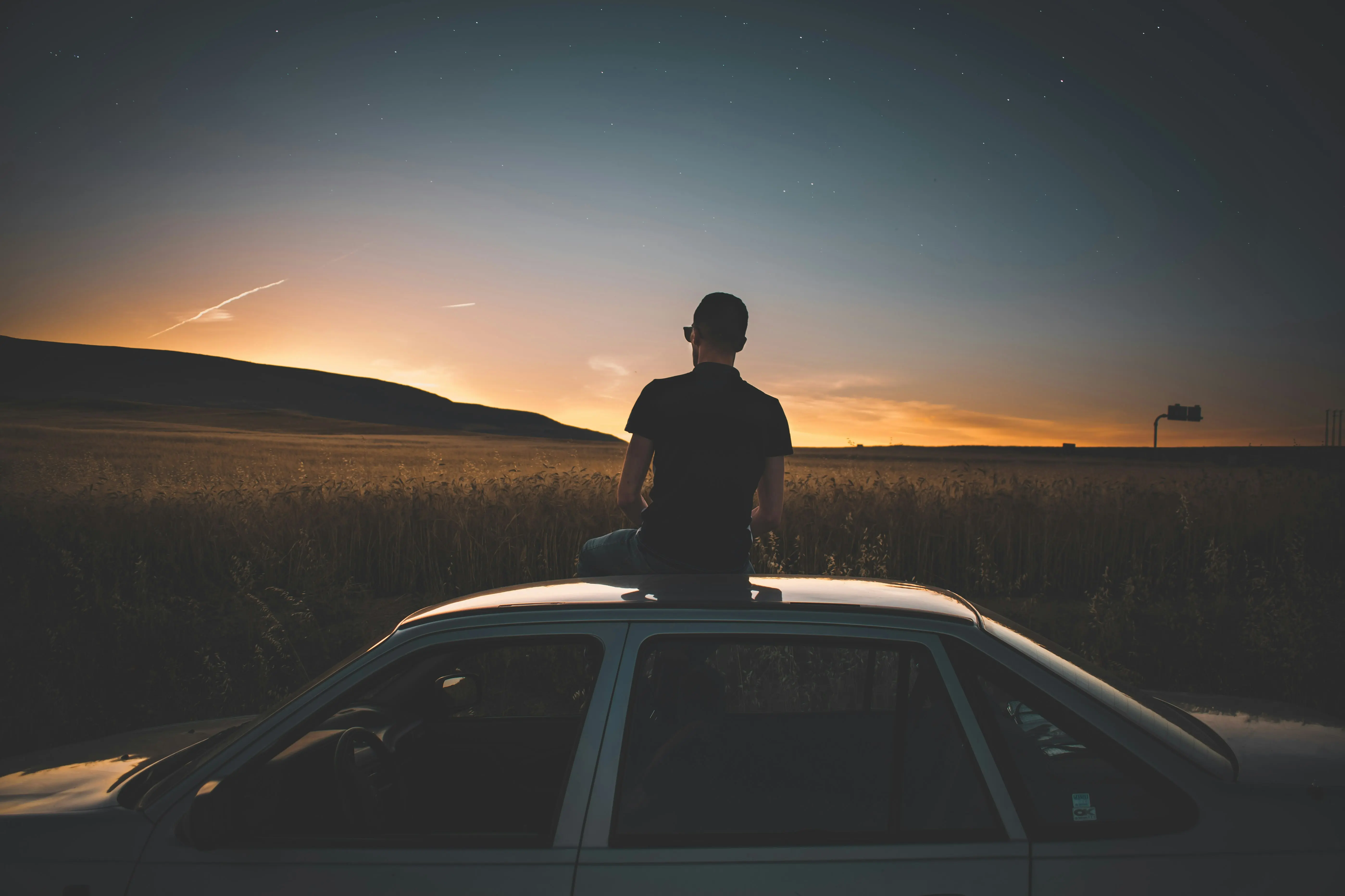 Person sitting above a car