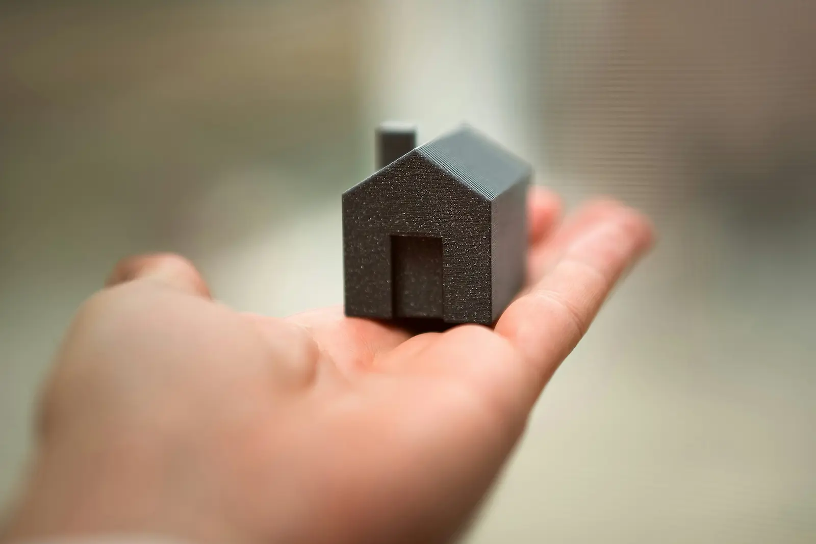 Miniature house on a person's hand
