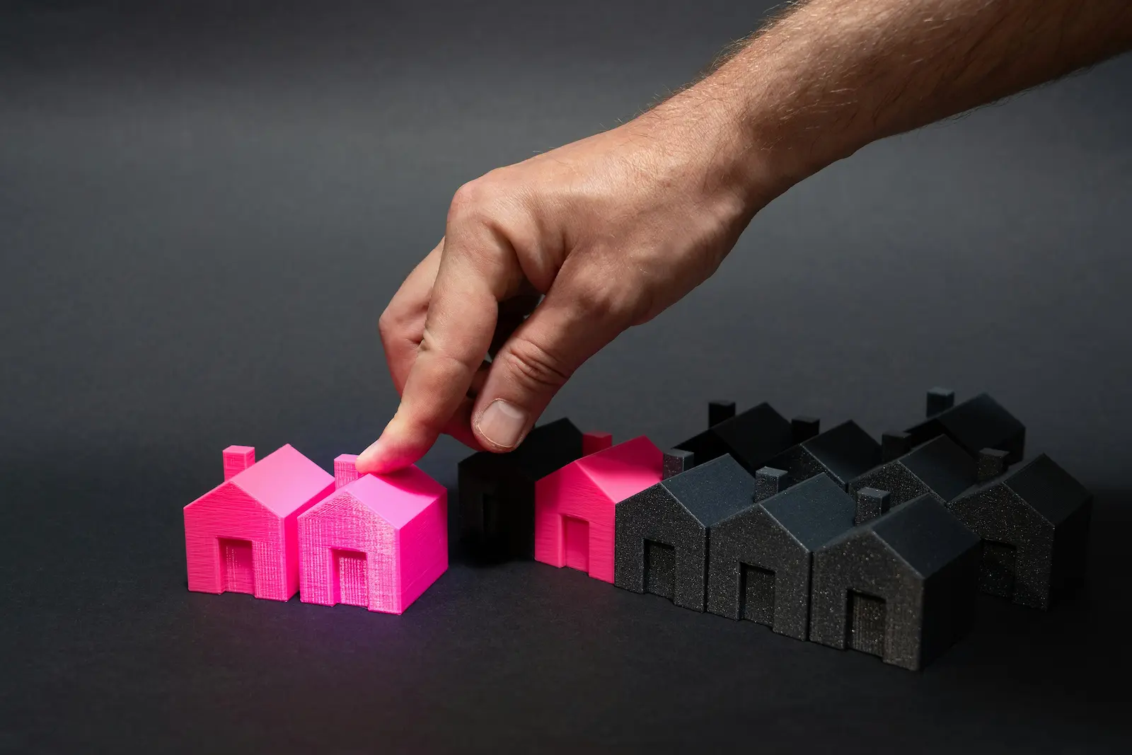 Person pointing at a miniature house
