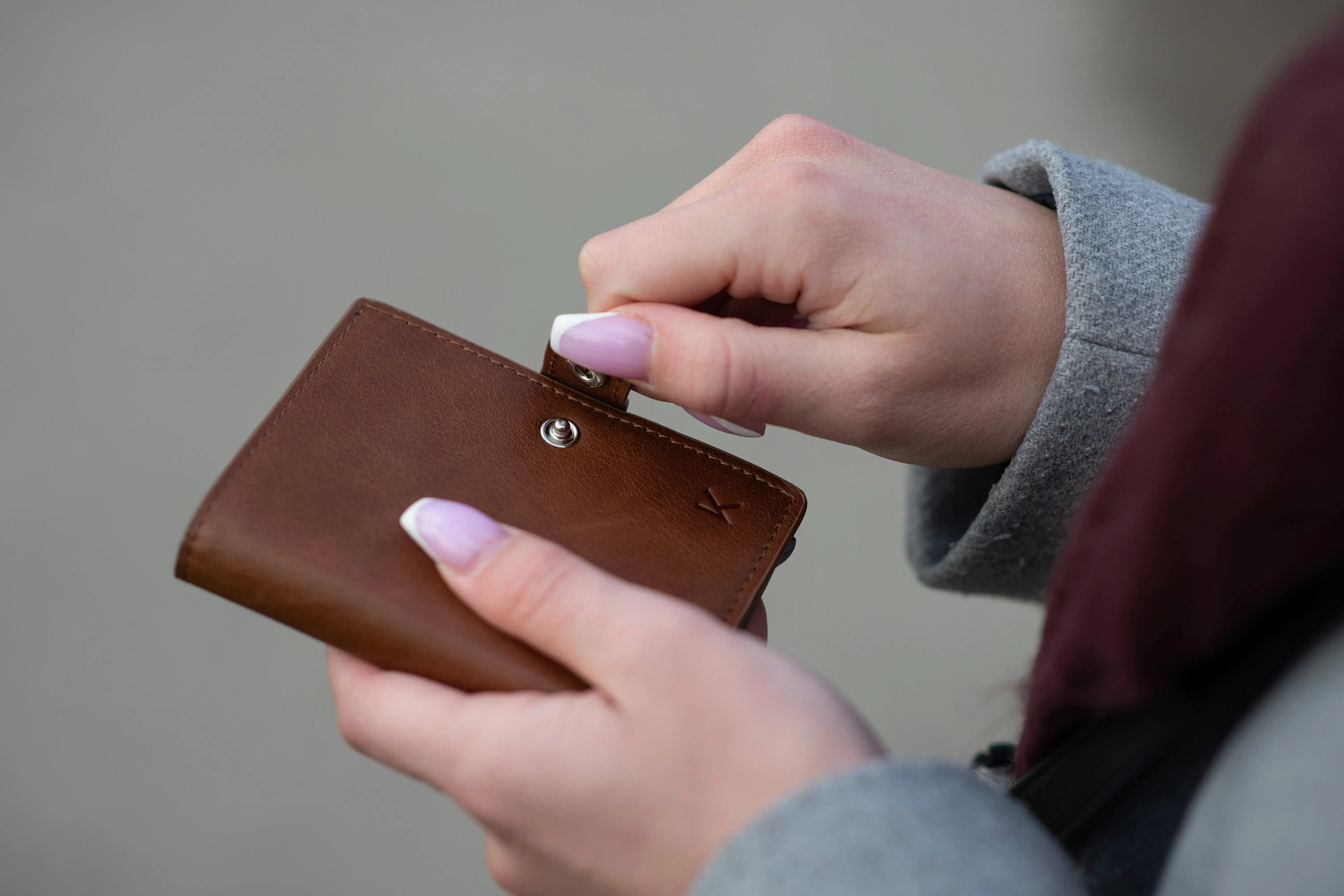 Person holding a brown wallet