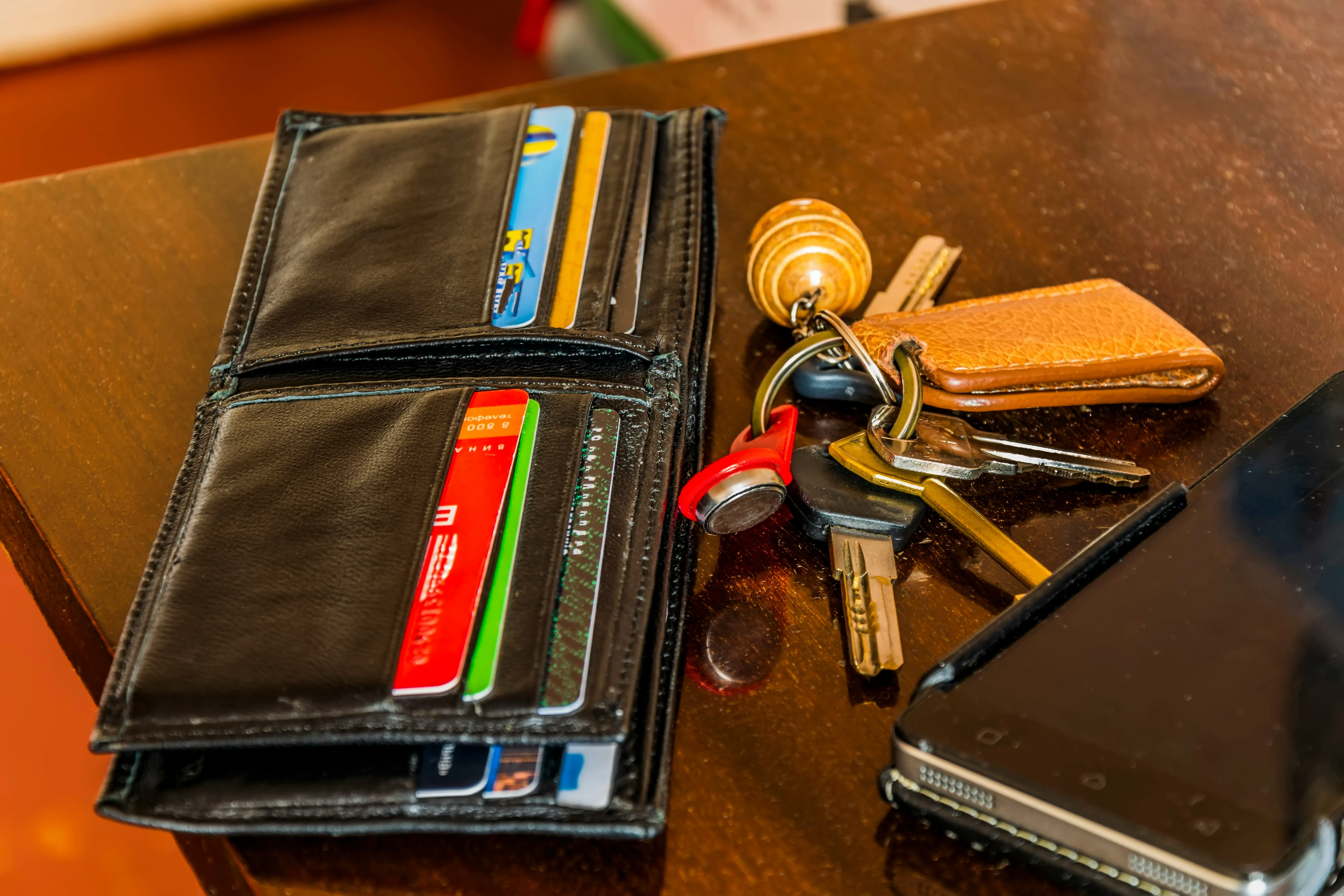 Keys, wallet, and a phone on a brown surface