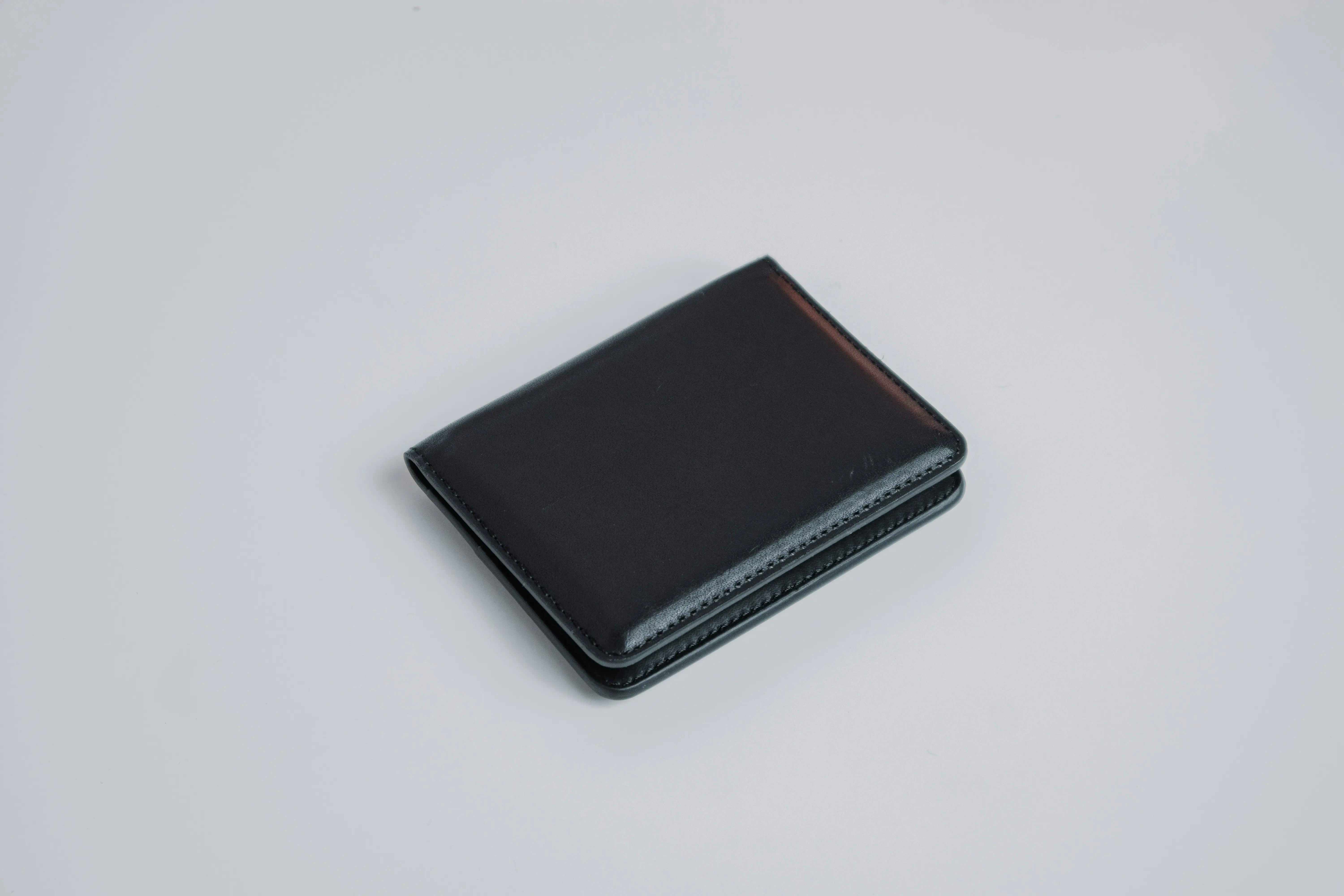 A black wallet on a white surface