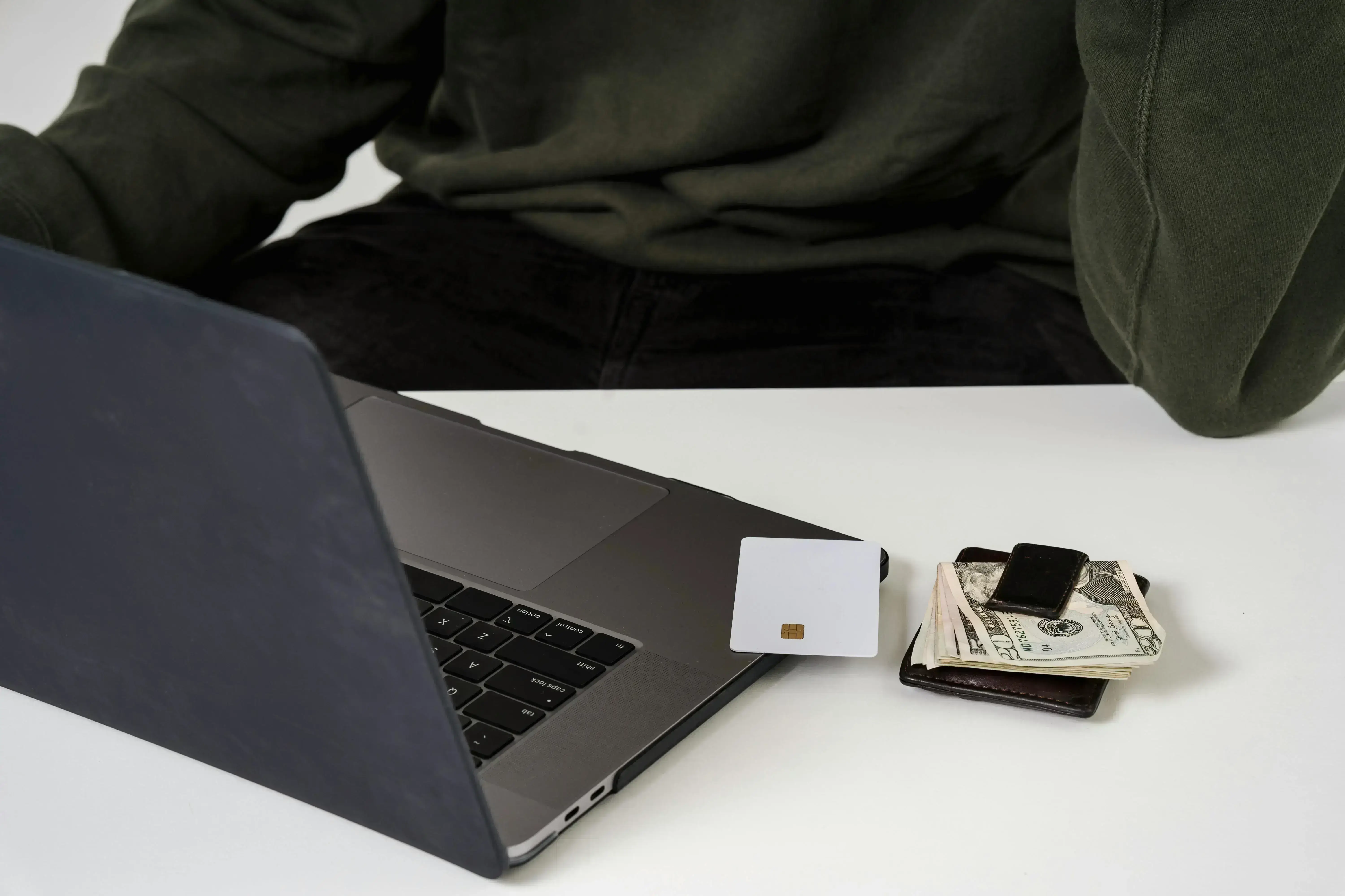 Laptop beside credit card and money