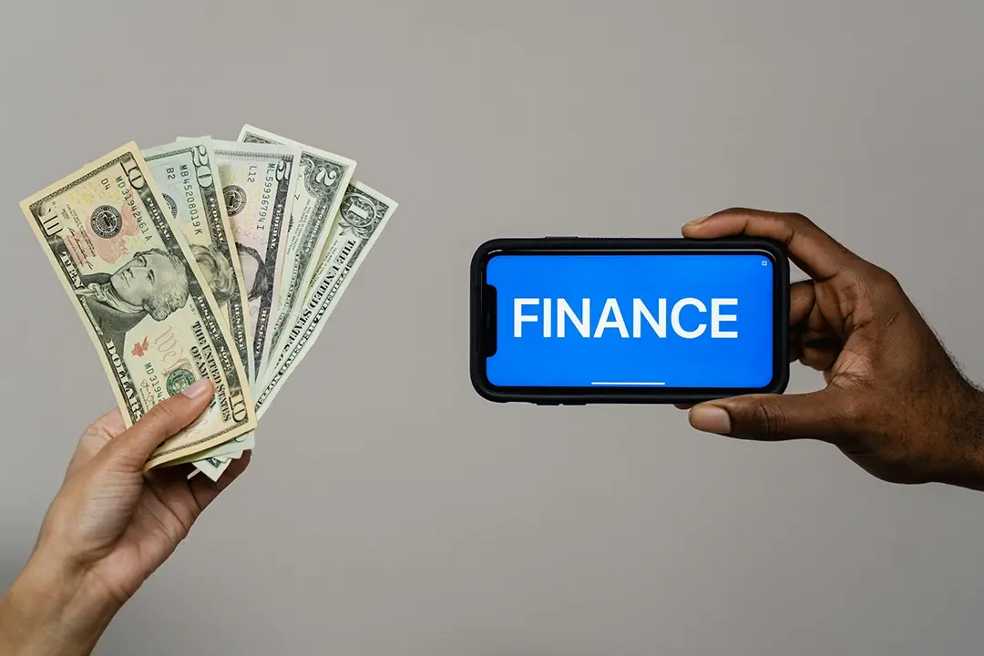Person holding money and a phone