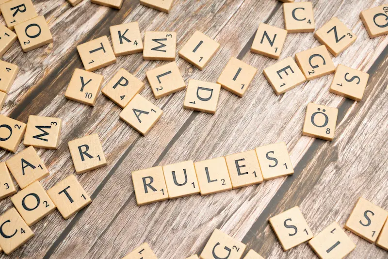 Scrabble tiles spelling RULES representing Chase credit card application rules 5/24 2/30 2026