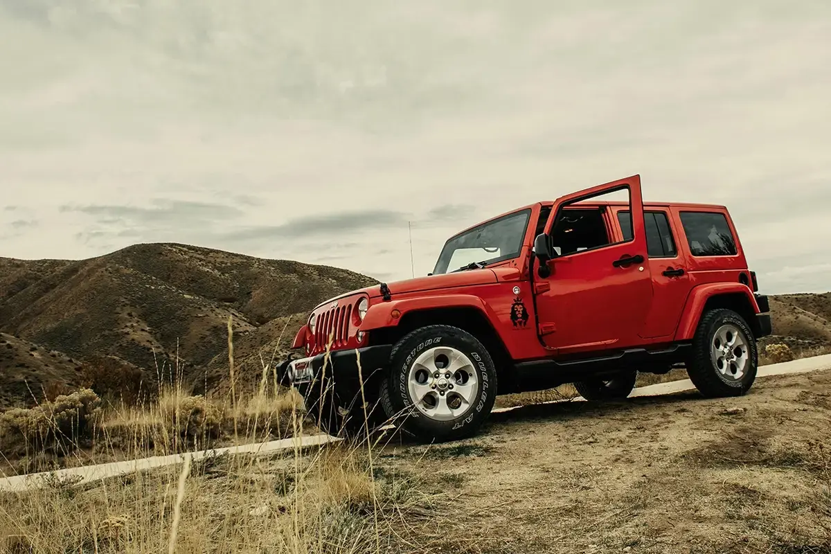 Red SUV on rough terrain highlighting need for free tire repair with Walmart Plus membership 2026