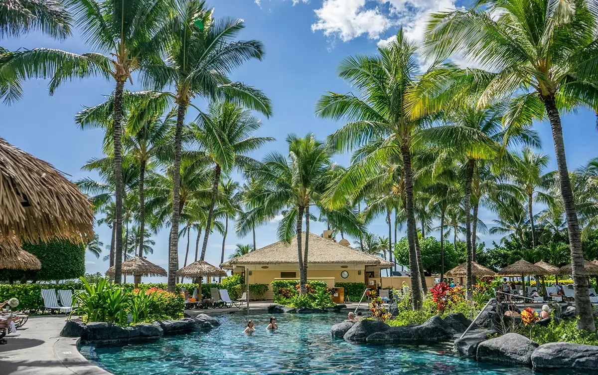 Tropical Hyatt resort pool with palm trees representing World of Hyatt Explorist status benefits unlocked by Chase Sapphire Reserve cardholders spending $75000 in 2026