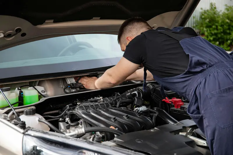 Mechanic performing car repair at an auto shop where a credit card can be used to pay the bill in 2026