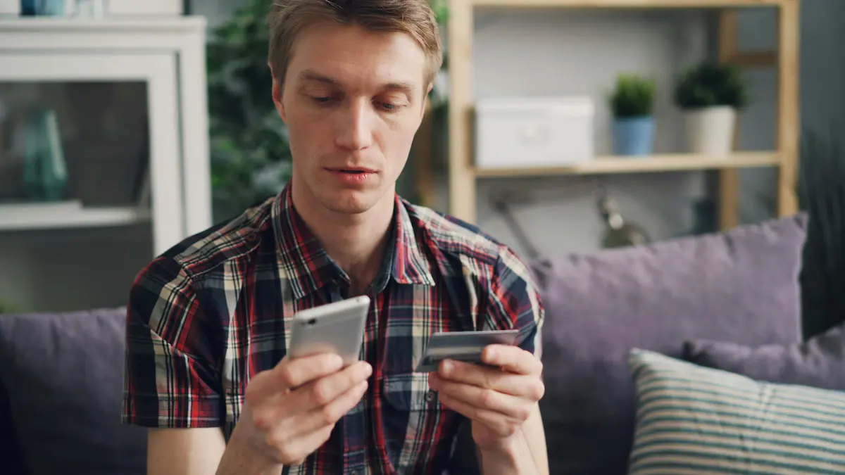 Person comparing two credit cards on a table to decide which cash back card is better in 2026