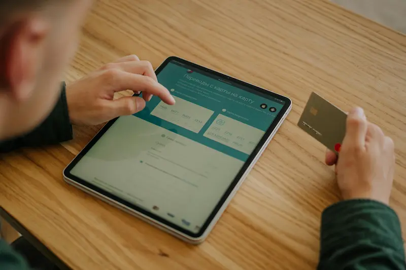 Person reviewing credit card options on a laptop weighing travel rewards versus cash back benefits