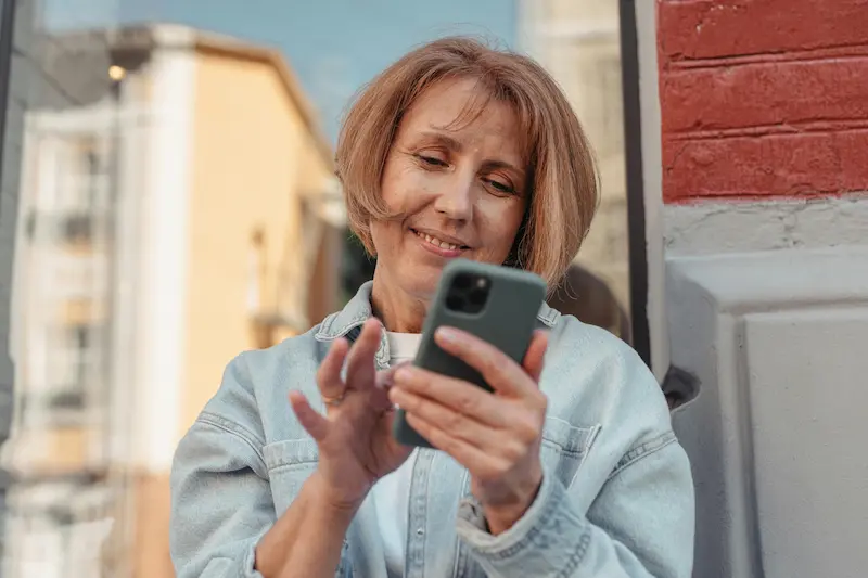 Person checking credit score on a phone before applying for a travel rewards credit card