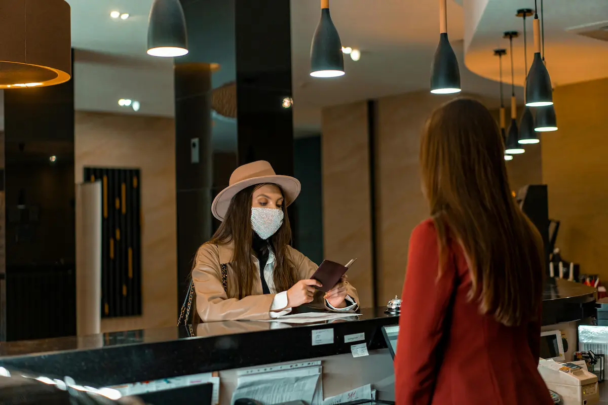Traveler checking into a hotel with a credit card at the front desk weighing flexible rewards versus hotel loyalty