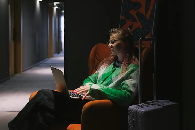 Person researching travel credit card options on a laptop comparing hotel loyalty versus flexible rewards