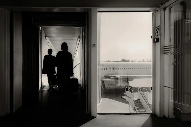 Traveler at airport boarding gate — Alaska Atmos Rewards members choose their preferred earning method starting in 2026