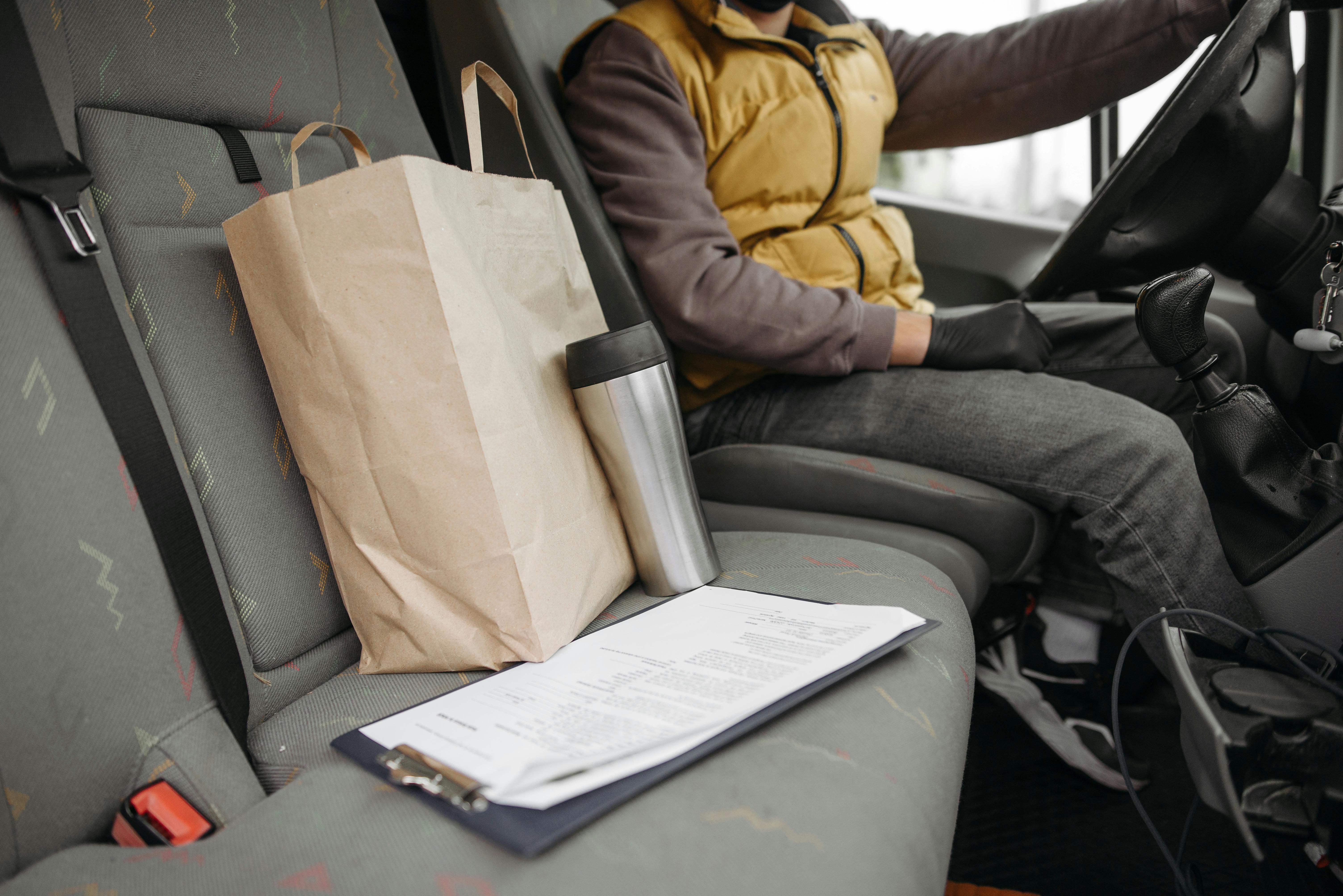 Person receiving a grocery delivery order representing World Mastercard Instacart and Lyft benefits on the Shell credit card