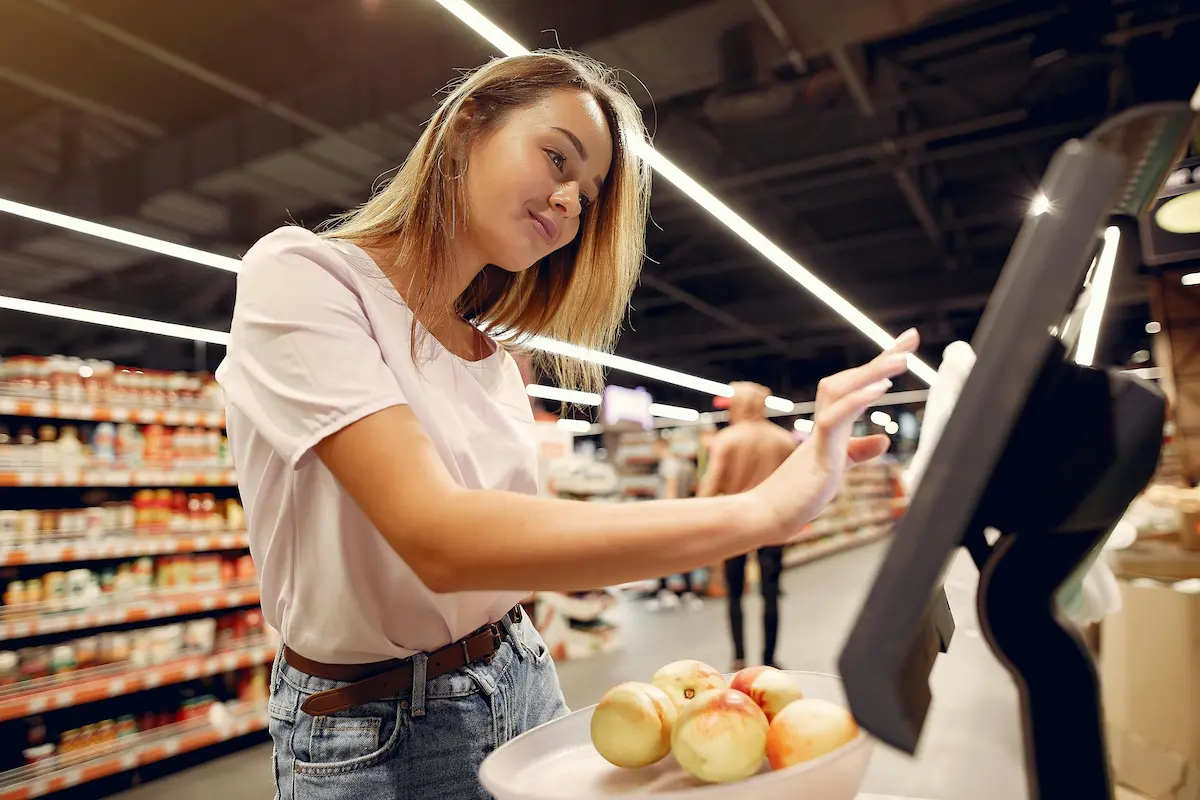 Person grocery shopping at a supermarket checkout — representing the AAA Daily Advantage Visa Signature card's leading cash back rate on grocery store purchases in 2026