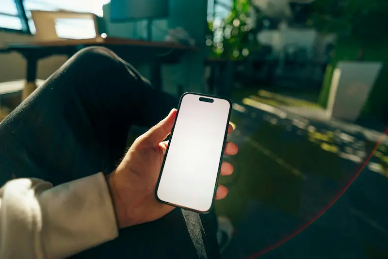 Person reviewing credit card rewards balance on a smartphone, illustrating the importance of monitoring the AAA Daily Advantage annual spending cap throughout the year