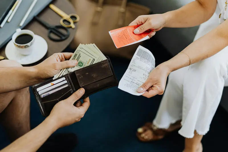 Homeowner using a credit card to pay for groceries, earning household rewards in 2026