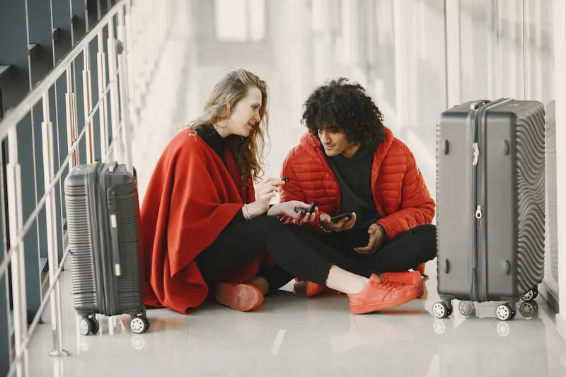 Two travelers at airport gate representing who benefits most from the Atmos Summit companion award in 2026