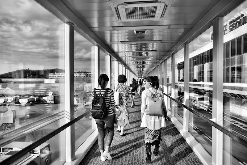 Traveler walking through connected airport terminals with carry-on luggage at Chicago O'Hare